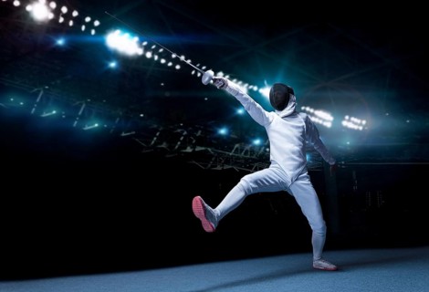 The fencer moves forward with a sword in his hand. Sport concept.