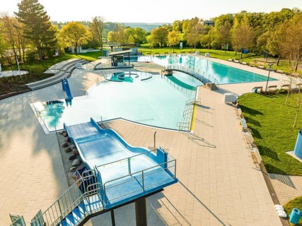Drone image of a swimming pool with water basin and slides at sunset