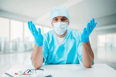 The doctor is perplexed and spreads his arms to the sides. Medicine concept.