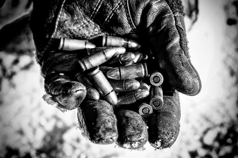 The fighter holds a handful of bullets in his palm for weapons.