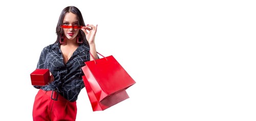 Beautiful sexy girl in glasses posing in the studio with red packages and a box for jewelry. White background. Shopping concept.