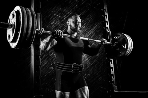 Professional athlete prepares to squat with a barbell.