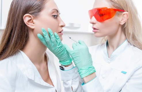 Portrait of two girls in white coats. The concept of cosmetology