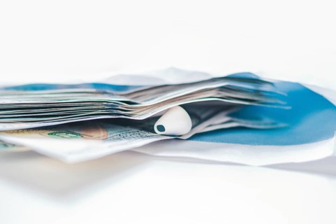Pack of hundred-dollar bills along with a bug lie in an envelope. The concept of bribery and corruption.