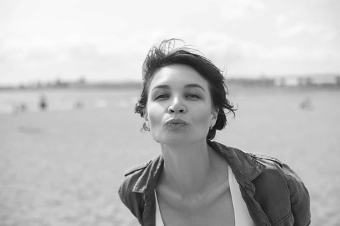 Portrait of a woman sending a kiss to the camera. Windy weather. Happiness