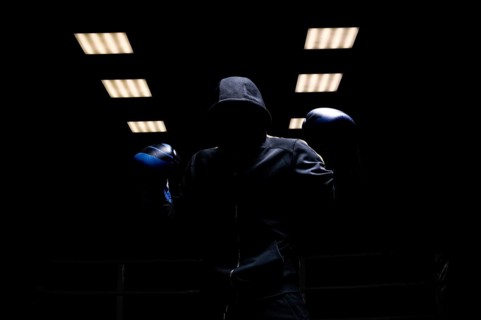 Fighter without a face is standing with his hands up. The concept of boxing