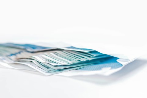 Pack of hundred-dollar bills lies in an envelope. The concept of bribery and corruption.