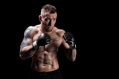 Mixed martial artist posing on a black background. Concept of mma