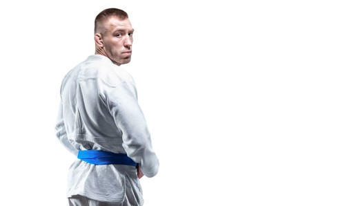 Strong man in a kimono looks over his shoulder. Concept of karate