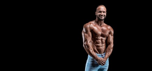 Isolated muscular man on a black background. Bodybuilding and fitness concept. Panorama.