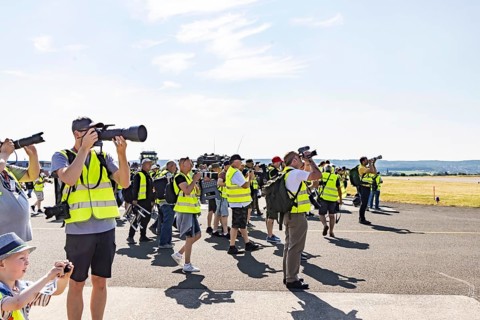 Photographers watch an air show