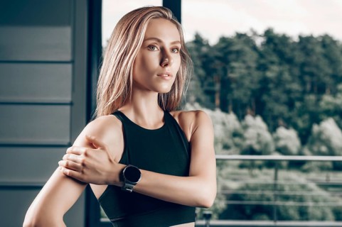 Charming girl posing with a smart watch. The concept of bodybuilding