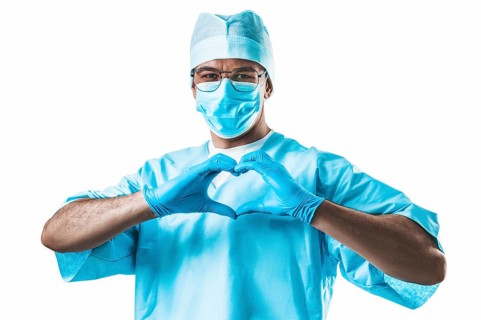 Portrait of a doctor on a white background. He folded his hands in the shape of a heart. Medicine concept.