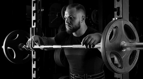 The weightlifter is near the bar