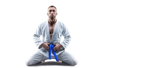 Athlete in a kimono with a blue belt sits and waits for the opponent. Concept of karate