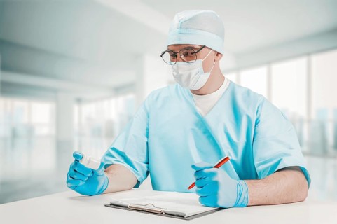 The doctor looks at the jar of pills and writes out a prescription. Medicine concept.