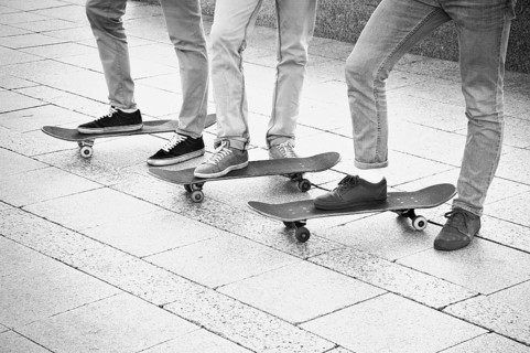Group of skateboarders are standing near their boards and are preparing to begin training