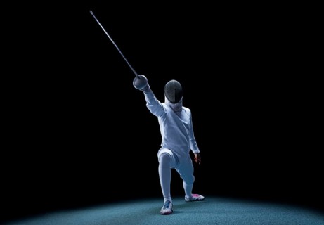 The fencer moves forward with a sword in his hand. Sport concept.