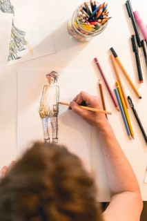 Top view of a fashion designer drawing a fashion sketch. Vertical shot