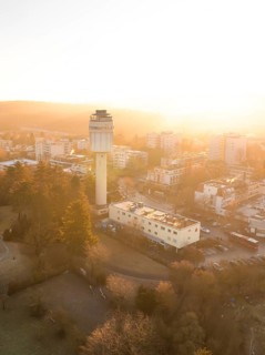 Aerial view of the water tower in the morning light of sunrise with the city skyline in the background