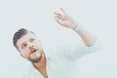 Stylish man in a shirt shows an ok sign right at the camera. The concept of success and support