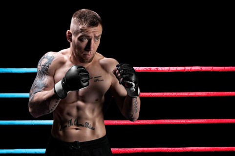 Mixed martial artist posing in boxing ring. Concept of mma