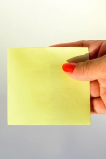 Woman's hand with painted nails holding blank letter paper on pure white background