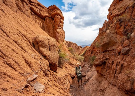 Mountaineer in a canyon with a dry stream bed