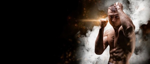Professional boxer posing in the studio. He stands in front of the camera and elbows. The concept of sport
