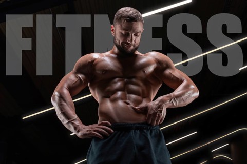 Portrait of an athletic muscular man who checks the condition of the abdominal muscles. Fitness concept