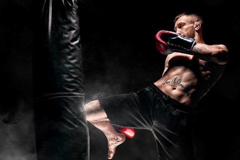 Kickboxer hits the bag with his knee. Training a professional athlete. The concept of mma
