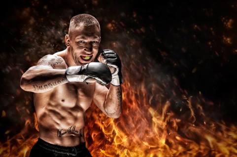 Mixed martial artist posing against the backdrop of fire and smoke. Concept of mma