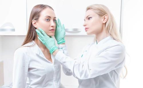 Beautiful girl at a consultation in the salon with a plastic surgeon. Beauty industry concept.