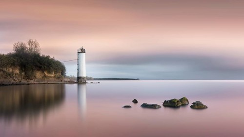 Long exposure of a colourful sunset behind the abandoned lighthouse on the Baltic Sea coast in Maltzien on Ruegen