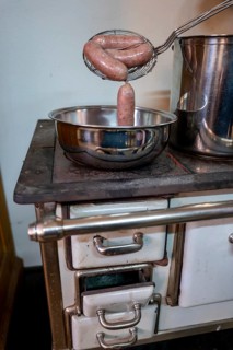 A Bowl with Luganighe Sausage on an Old Kitchen Stove in Lugano