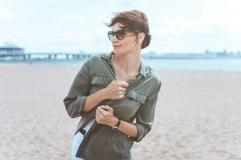 Image of a beautiful woman on the beach of the Gulf of Finland in St. Petersburg. Windy weather. Happiness