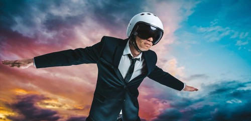 Portrait of a man in a suit and helmet. He is flying in the sky. Business concept.
