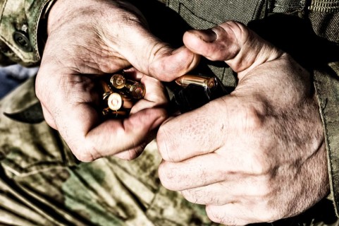 The fighter prepares a clip with bullets before the next fight.