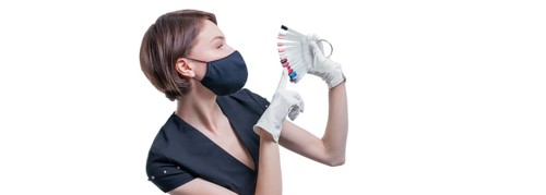 Portrait of an elegant beautiful girl wearing a protective mask with a set of nail palette in hand. White background. Advertising banner for beauty salons during Covid-19. Pandemic. Modern trends