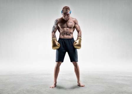 Professional wrestler is standing in a bright room. Mixed martial arts