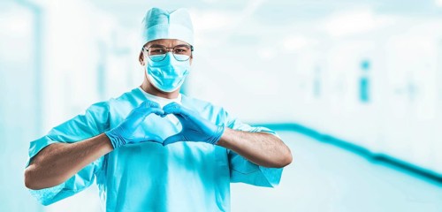 Portrait of a doctor in a hospital. He folded his hands in the shape of a heart. Medicine concept.