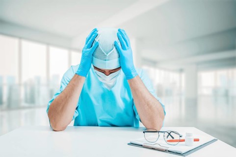 The doctor is upset and holds his hands behind his head. Medicine concept.