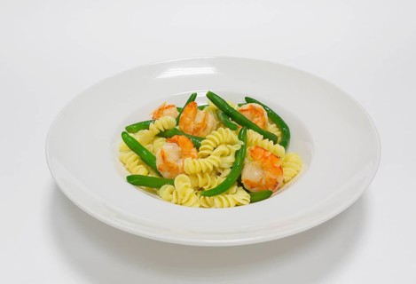 Gourmet pasta with tiger prawns and green beans. Top view. White background. Healthy eating concept.
