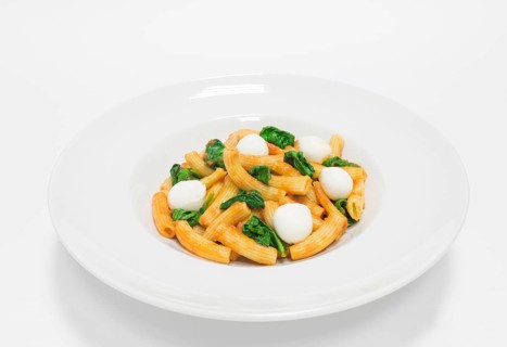 Gourmet pasta with basil and mozzarella balls. Top view. White background. Healthy eating concept.