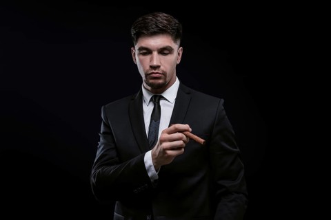 Portrait of a stylish man in a suit with a cigar. Business concept.