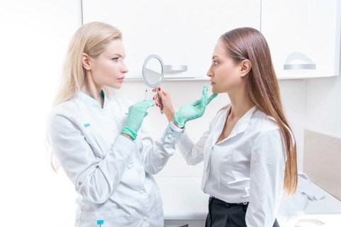 Portrait of the beautician and patient. The doctor injects botox. Skin rejuvenation and lifting concept.