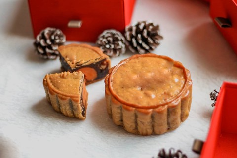A single mooncake piece placed prominently with a festive backdrop