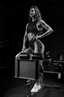 Adorable brunette poses in training apparatus in the gym. Fitness and bodybuilding concept.