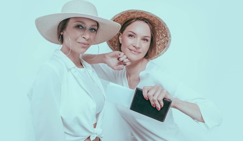 Portrait of two smiling women with passports and boarding passes in their hands. Travel concept.
