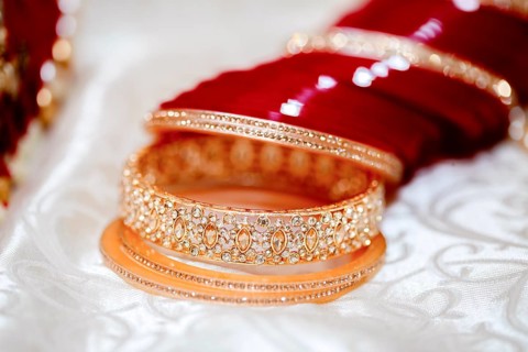 Close-up of traditional golden bangles on a red velvet background exuding luxury and elegance
